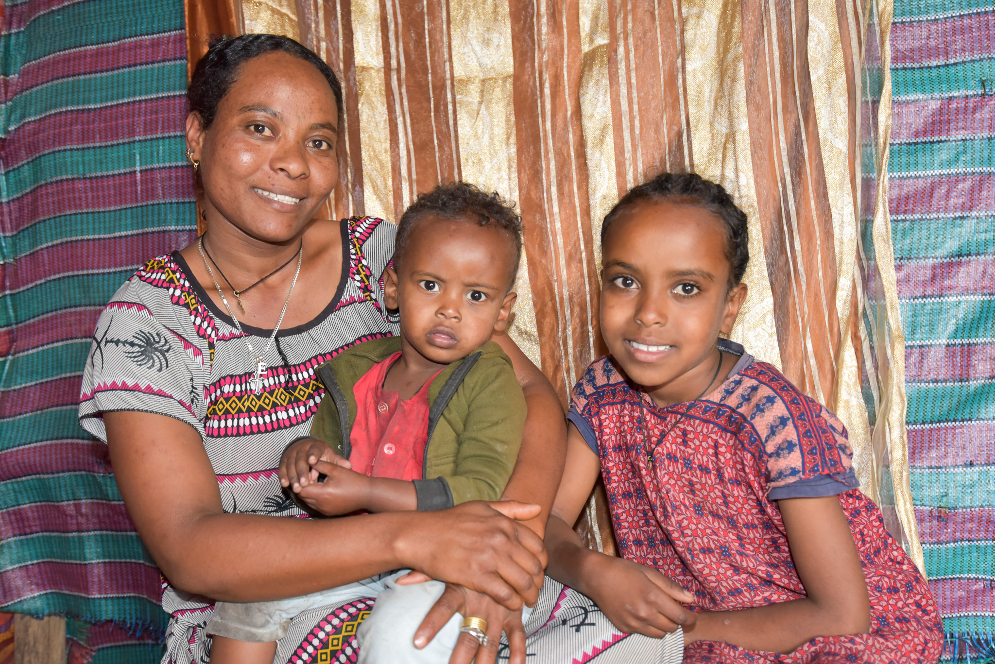 Emebet with her two kids at their current home. 