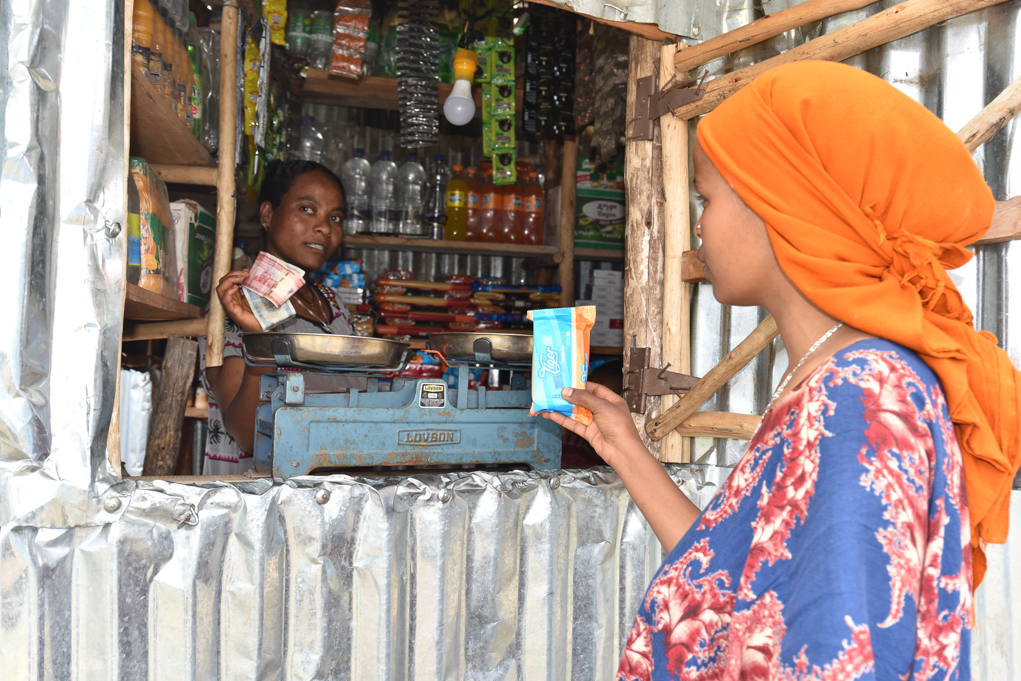 Emebet serves a customer at the retail shop she opened after the support by UN Women.