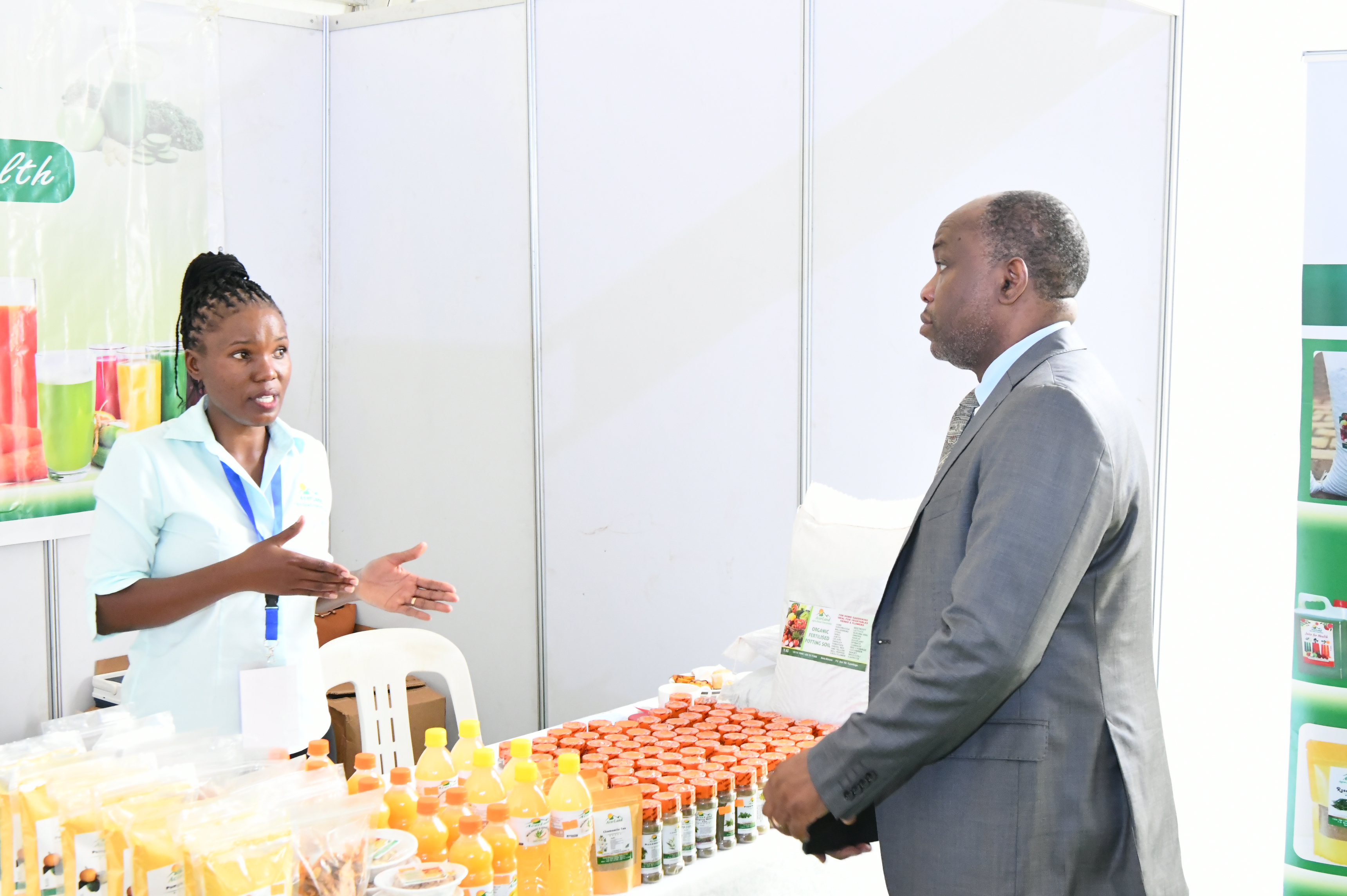 Maxime (Right) listening to one of the fruit exhibitors at the event in Sheraton Hotel-Kigo, Kampala.