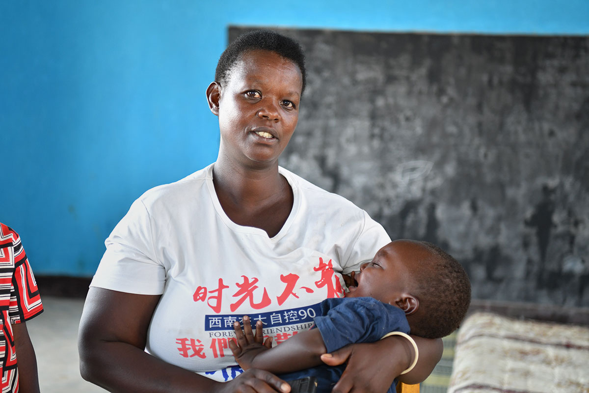 Christine Mukamana is seen with her youngest son at the Early Childhood Development Centre in Munini Sector, Rwanda. Photo: UN Women/Geno Ochieng
