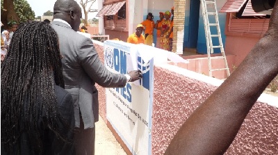 Placing of the UN Women Logo to the wall of the Kullimaaro shelter (Photo Credit: Women/ L. Sanka)