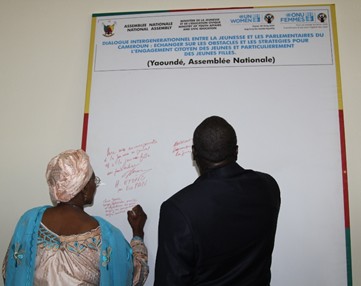 Minister Marie-Therese Abena (MINPROFF) and Minister Mounouna Foutsou (MINJEC) signing the commitment. Photo credit, Teclaire Same, UN Women