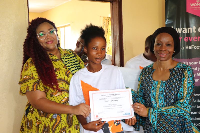 Mercy Beyan from Bong County in the north-central part of Liberia receives her certificate from Sara Buchanan, Executive Director of Orange Foundation Liberia (L) and Comfort Lamptey, UN Women Liberia Country Representative ® after completing a six month digital literacy skills training program facilitated by UN Women in collaboration with Orange Foundation. Photo credit @UN Women/ Gloriah Ganyani