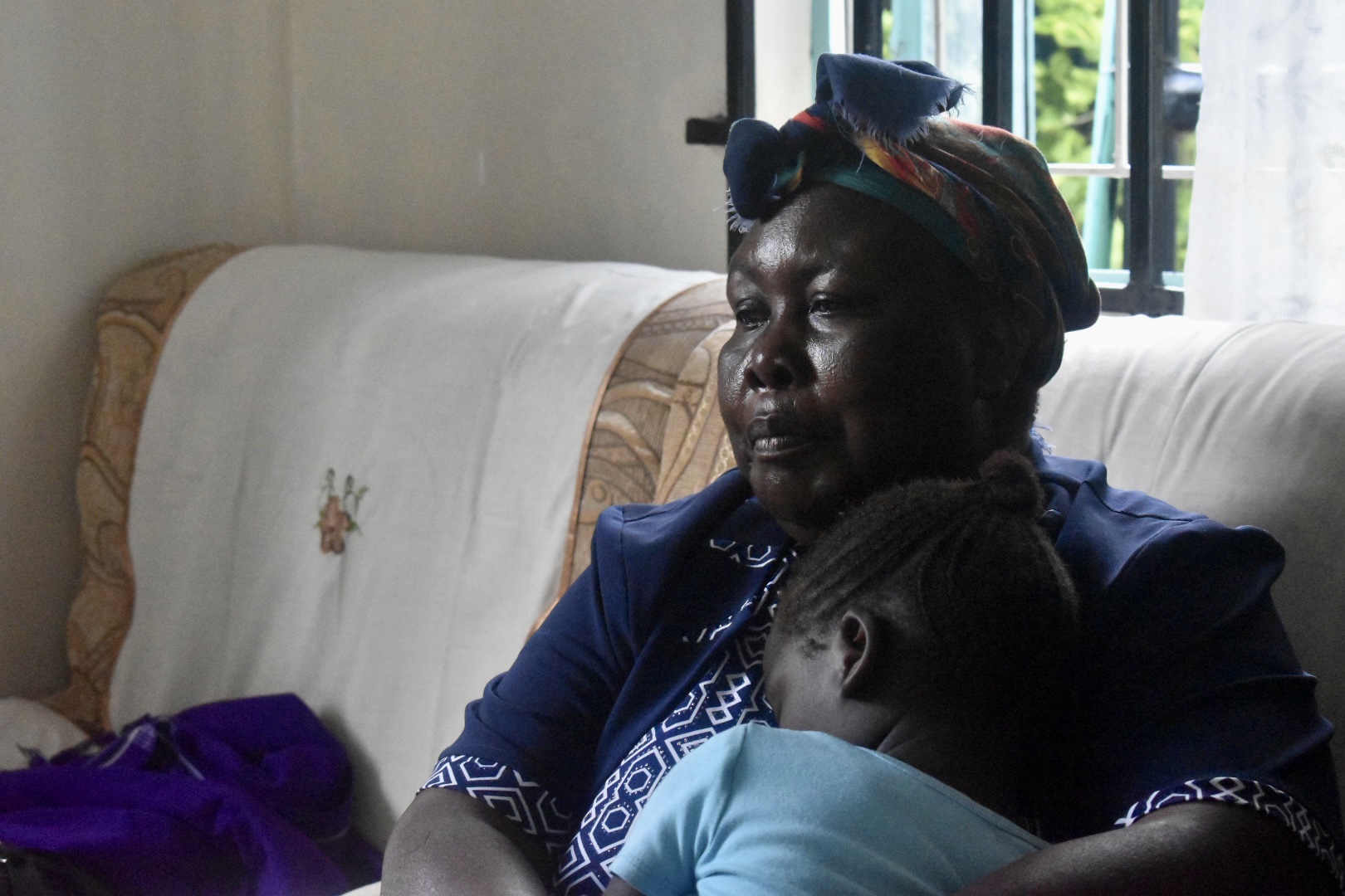  Jael Abukutsa holding one of the young survivors at he Blessed Safe Haven Shelter. Photo: UN Women/Tabitha Icuga
