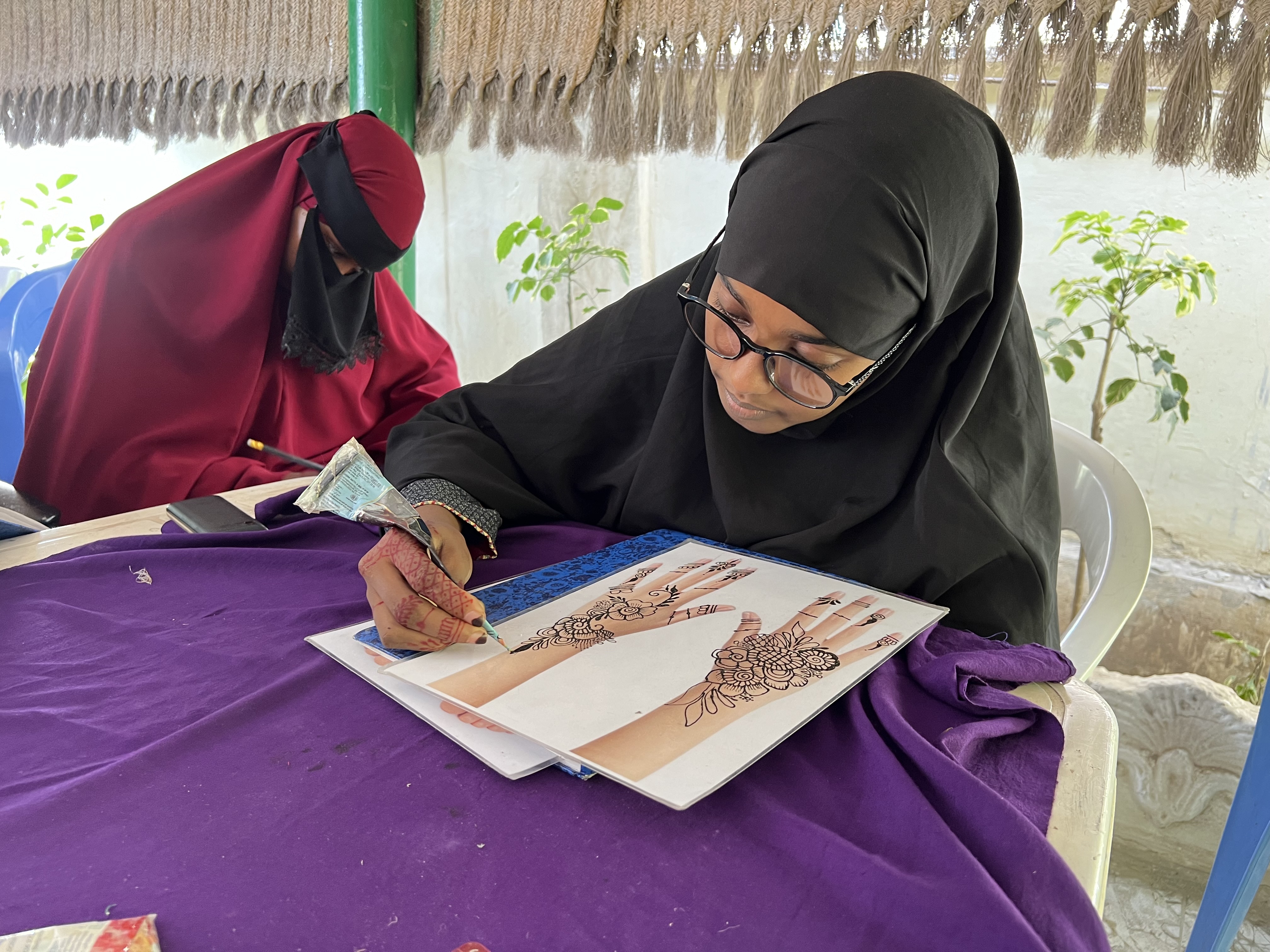 Farhia practicing henna skills at a training session (Photo courtesy of NAPAD)