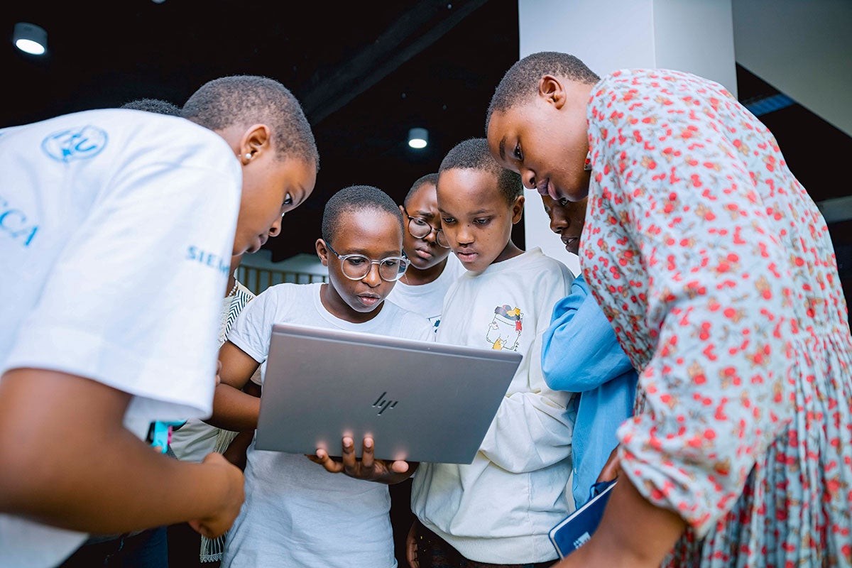 Young women participants work together on a laptop at during an African Girls Can Code Initiative's coding bootcamp held at the GIZ Digital Transformation Center in Kigali, Rwanda in April 2024. Photo: UN Women