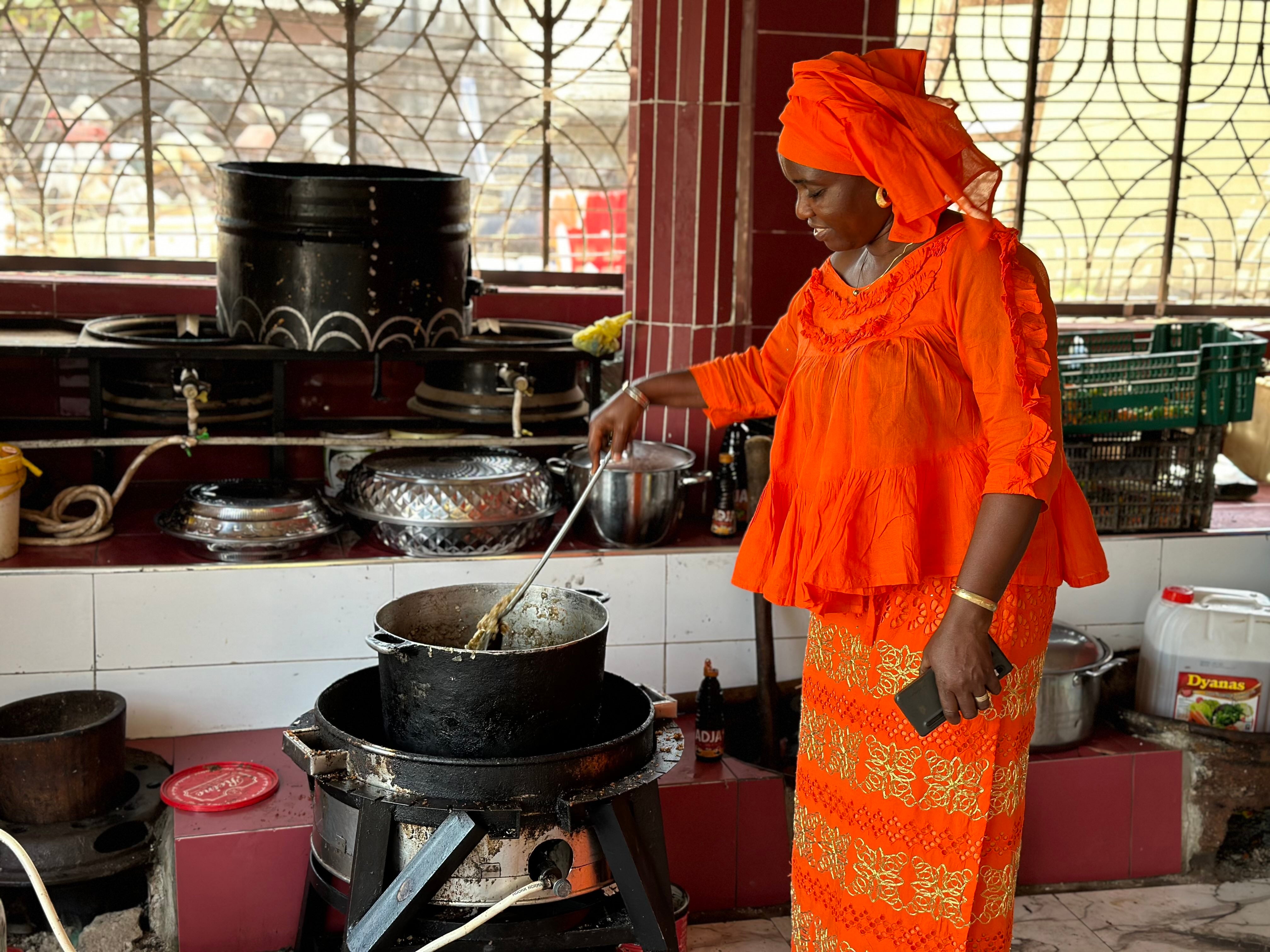 Tida Sadio en train de cuisiner dans son restaurant.