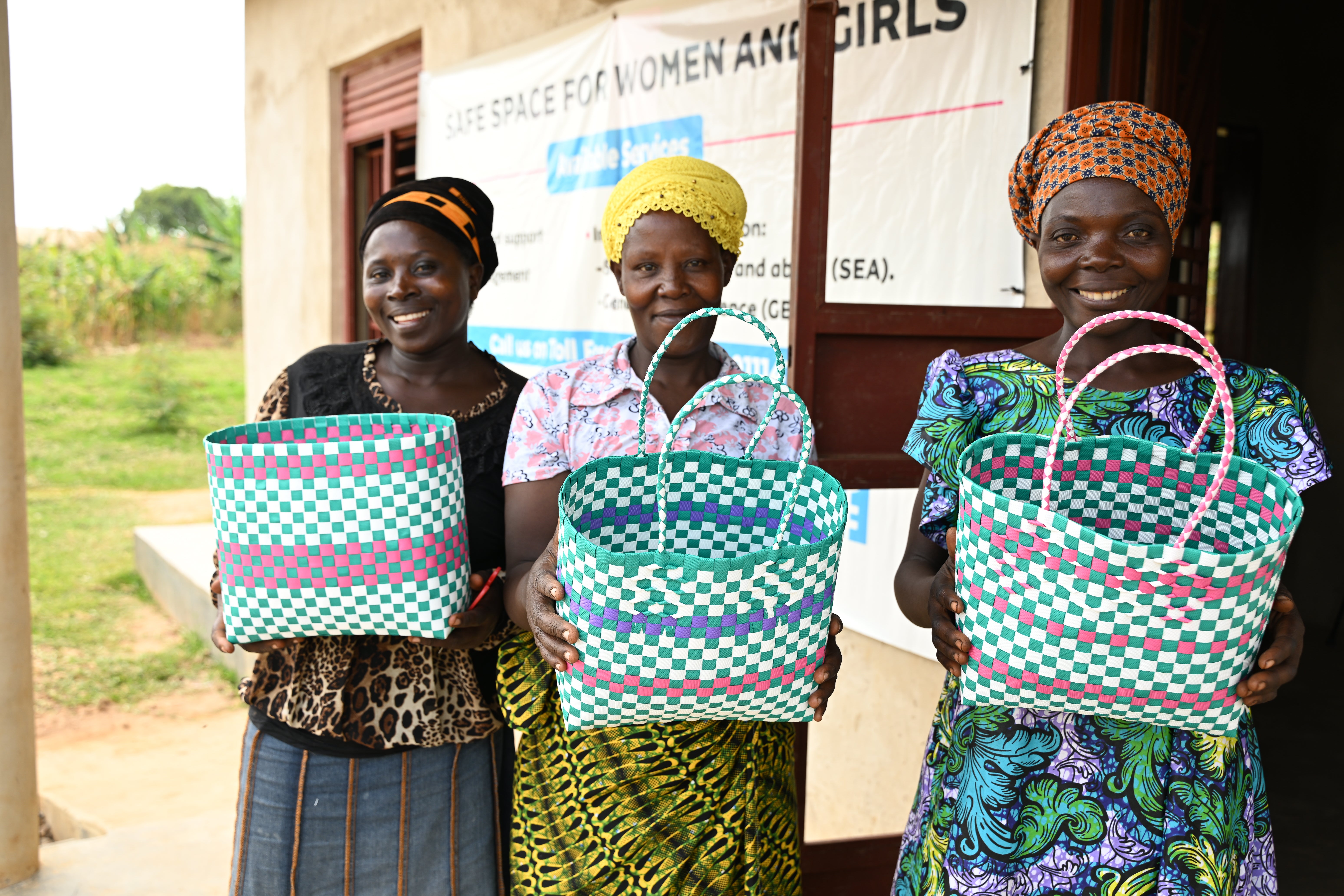 Some of the members of New Hope VSLA displaying baskets they make as a group to earn income. The group meets at the safe space constructed in their community by UN Women with funding from the UN CERF. Photo credit: UN Women / James Ochweri