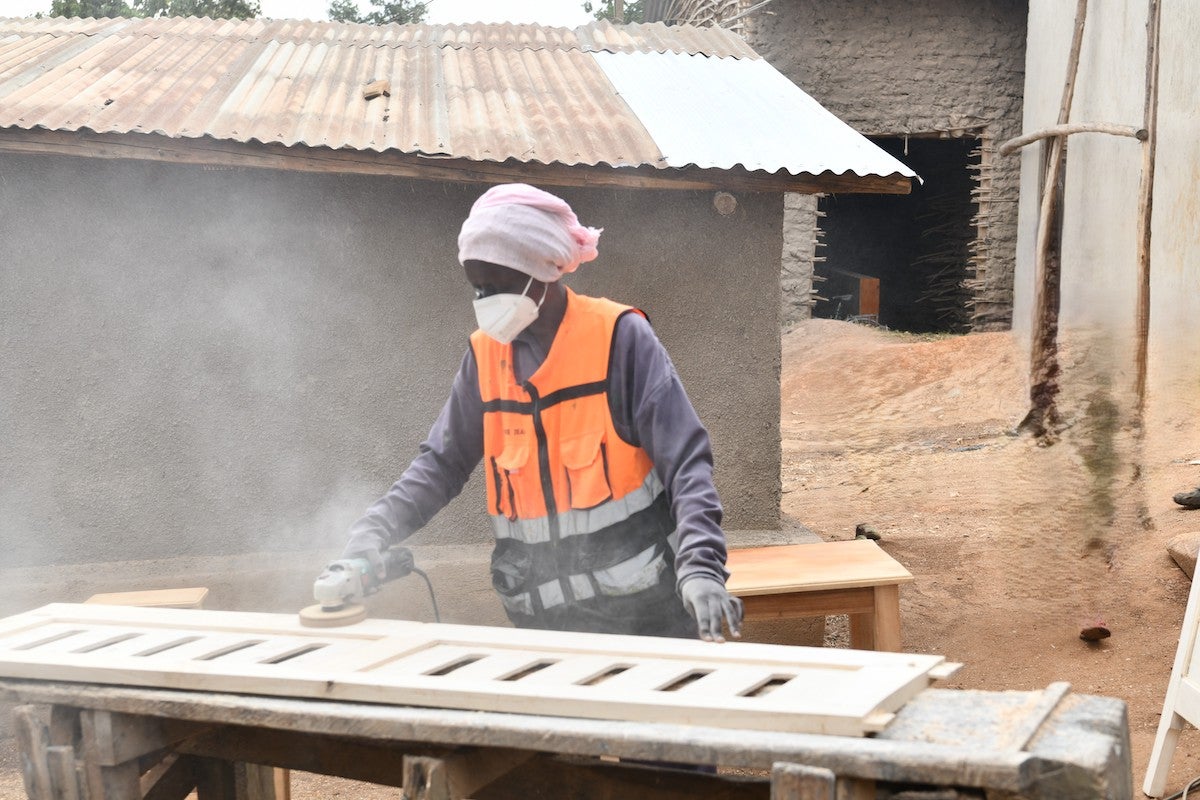 Shekinah at the workshop working on a door. Photo Credit: UN Women/Allen Ankunda