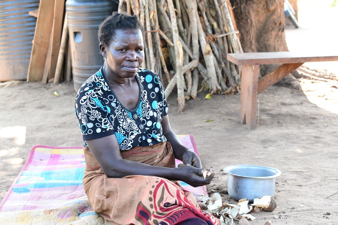 Laker peeling cassava to prepare a lunch meal for her family. 