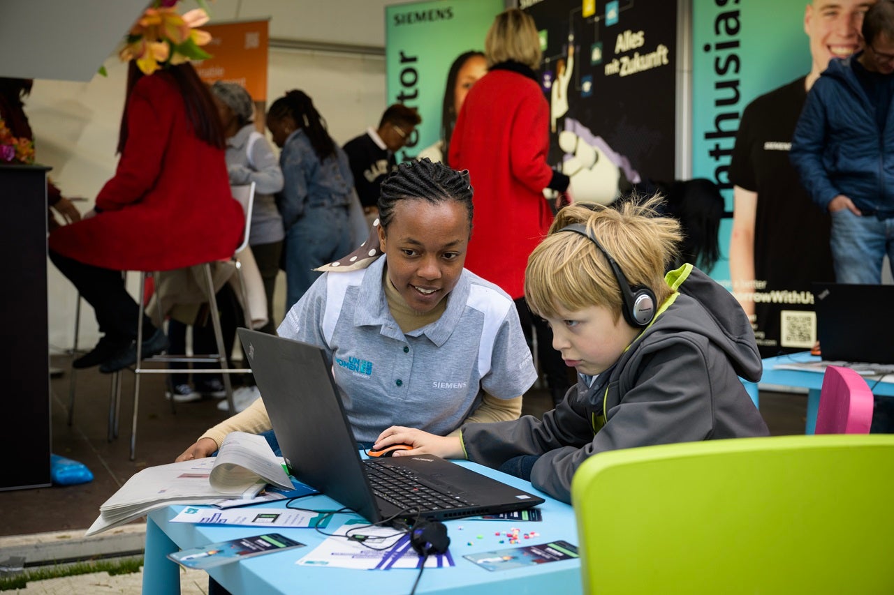 Lucide teaching young children how to code during the Bürgerfest Citizens' Festival at Bellevue Palace in Berlin.