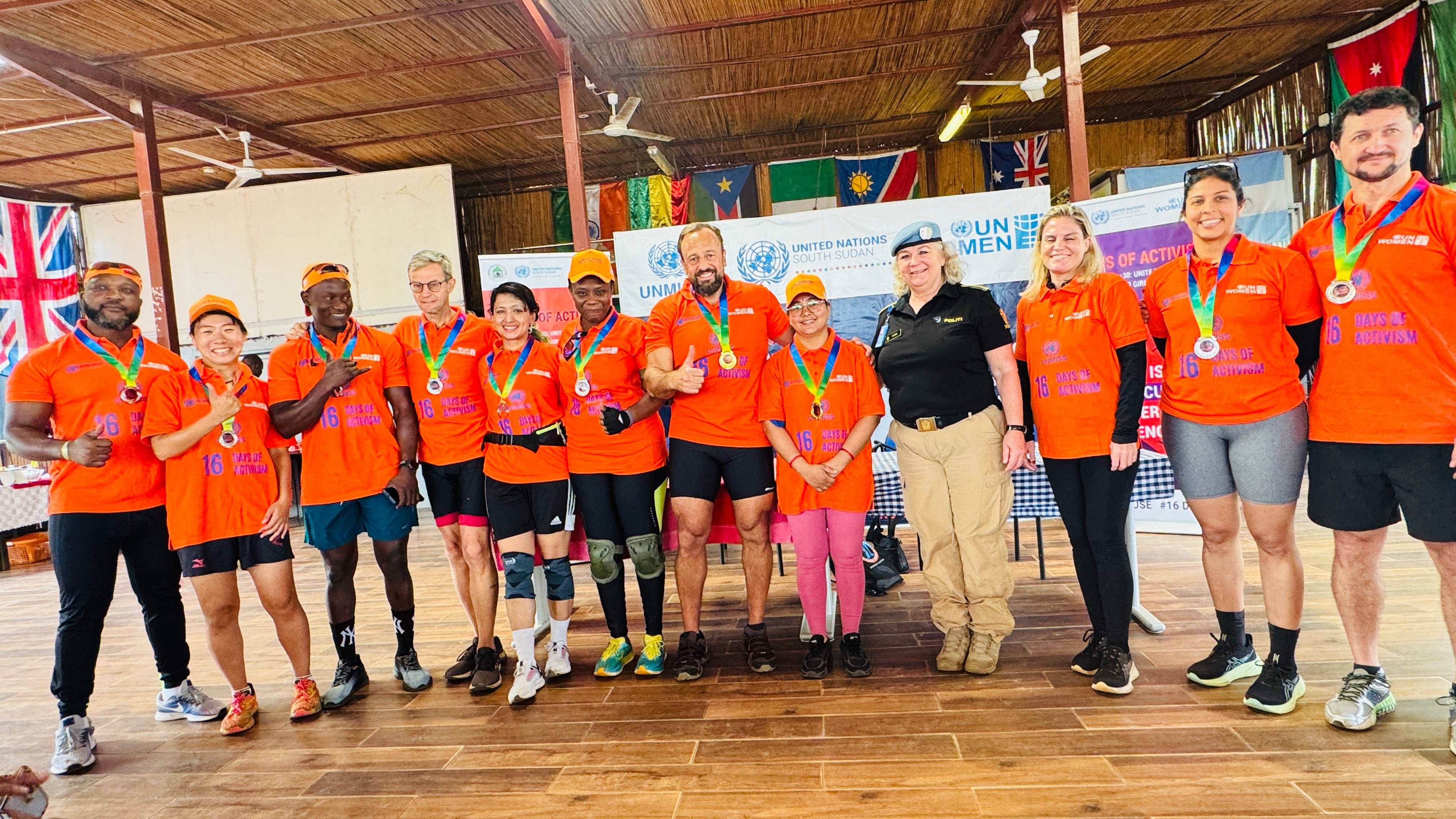 The top 10 winning cyclists, comprising 5 women and 5 men, stand with speakers, representing equality and shared responsibility in the fight against GBV after the cycling race.