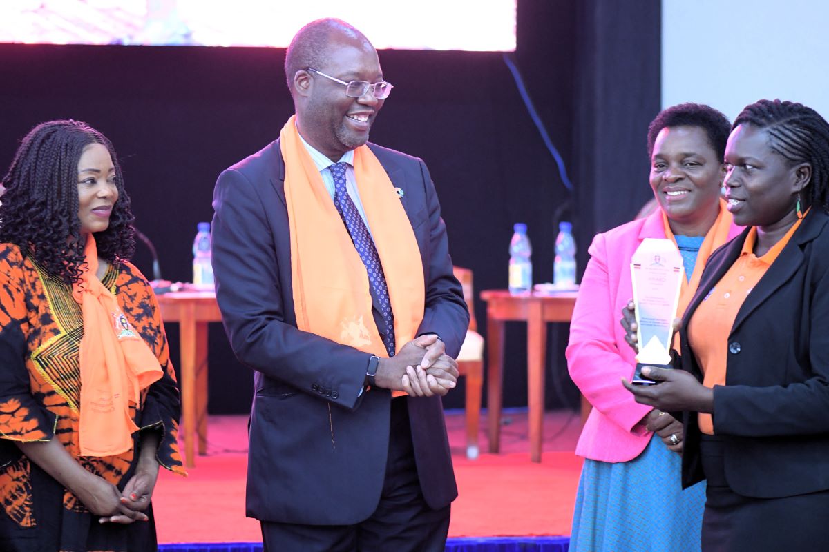 Mr. Leonard Zulu, UN Resident Coordinator to Uganda gestures at Diana Oroma a staff of Women’s International Peace Centre who received an accolade during the national launch of 16 Days of Activism Campaign in Kampala