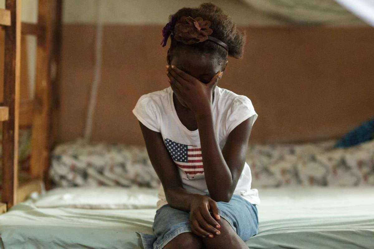 Rebecca (name changed), 10, sits on her bed in the dorm of the safe house of UNICEF partner NGO Amazonian Initiative Movement in the town of Masethleh, Port Loko District, Sierra Leone. She ran away from her home where her familiy was planning on training her as a female genital mutilation practioner. Photo: UNICEF/UNI150843/Asselin.