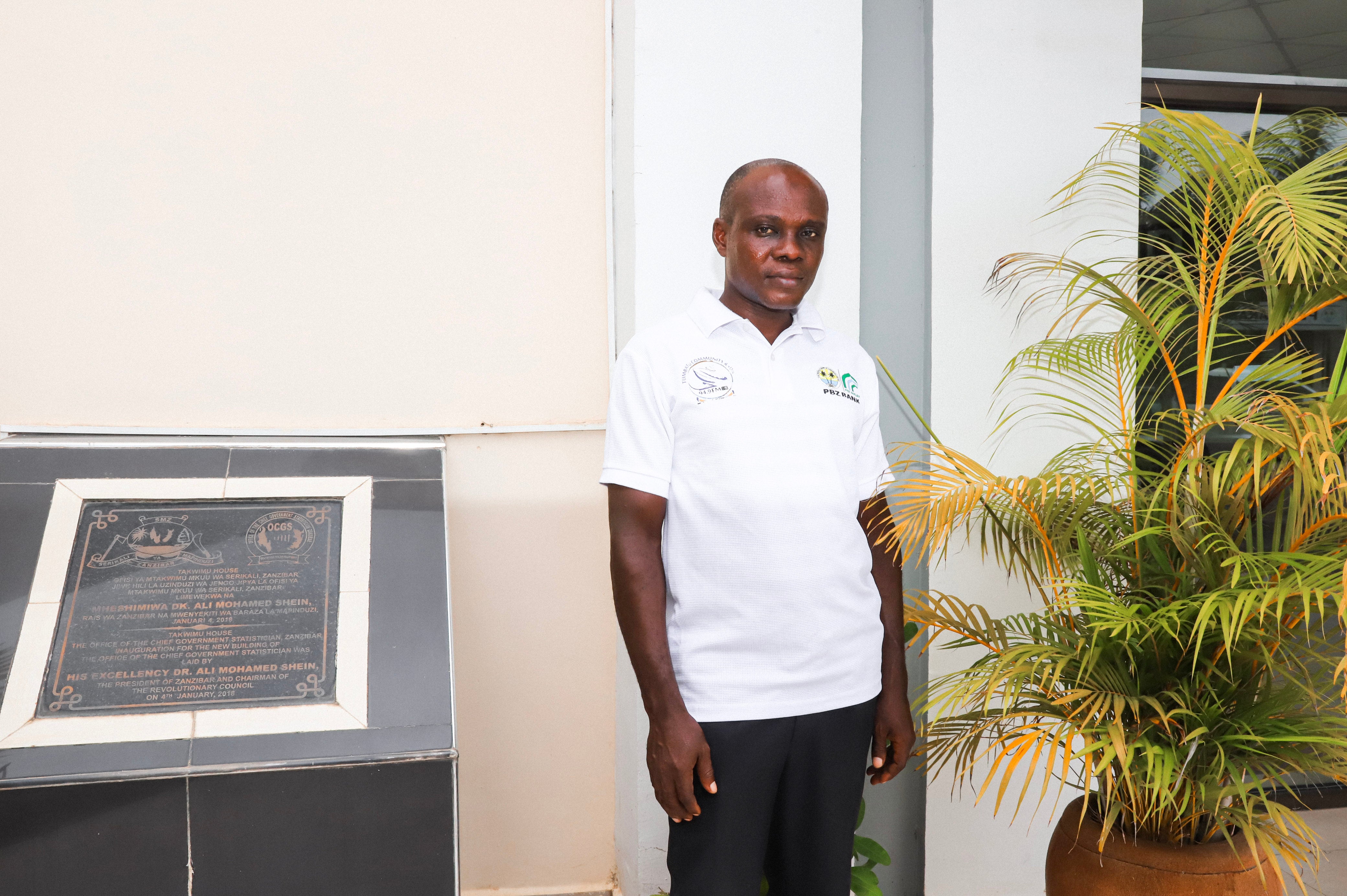 Juma Haji Juma, a community radio presenter for Tumbatu FM in Zanzibar posing in front of the Zanzibar Office of the Chief Government Statitistican 