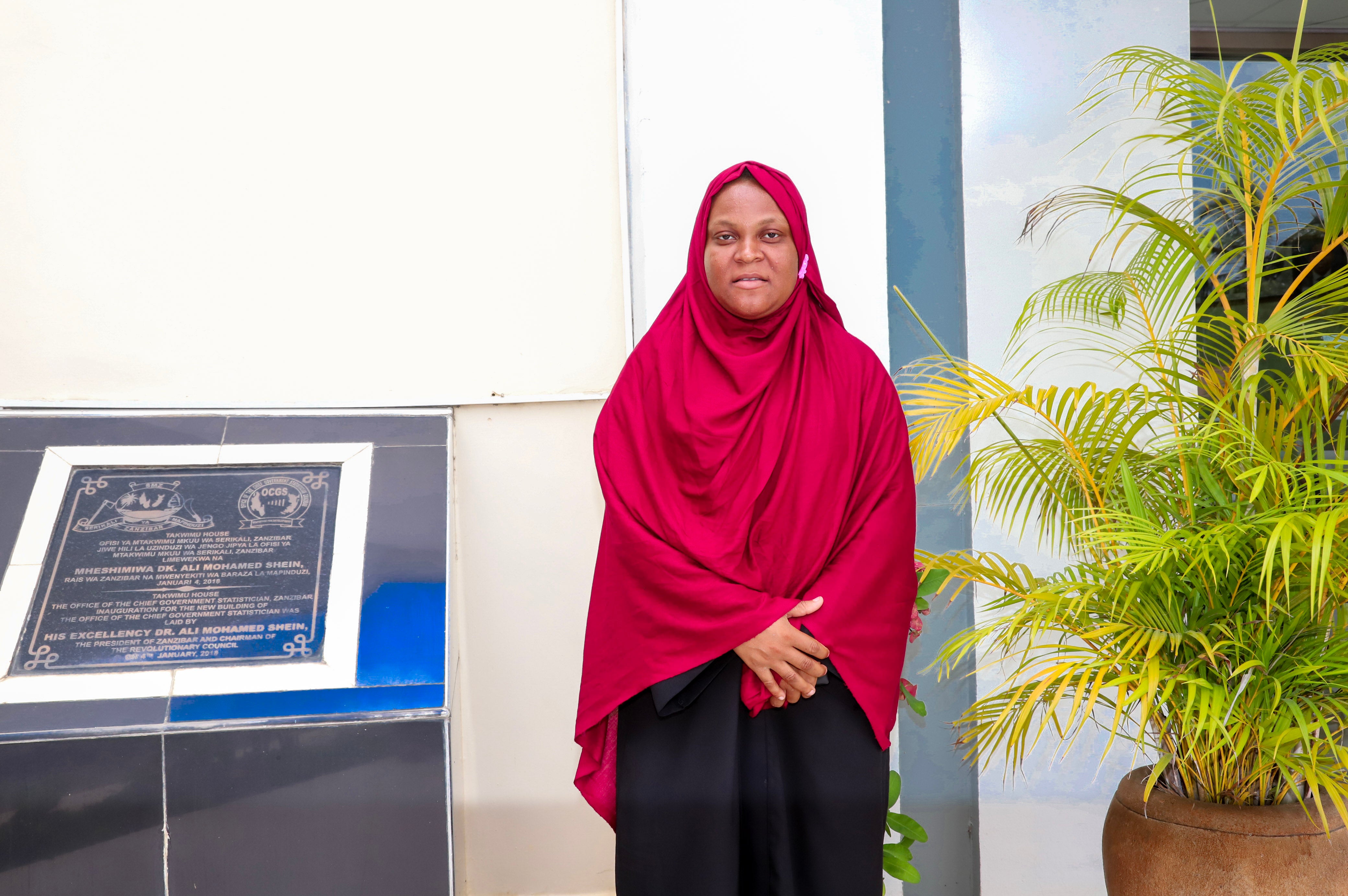 Fatma Haji Silima posing in front of the Office of the Chief Government Statistician in Zanzibar