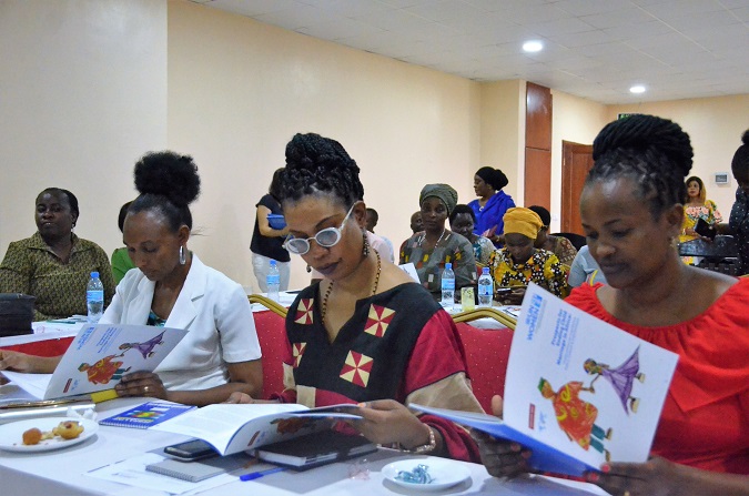 Participants read through the Child Marriage Study report after it was launched in Dodoma on 5 March. UN Women/Tsitsi Matope