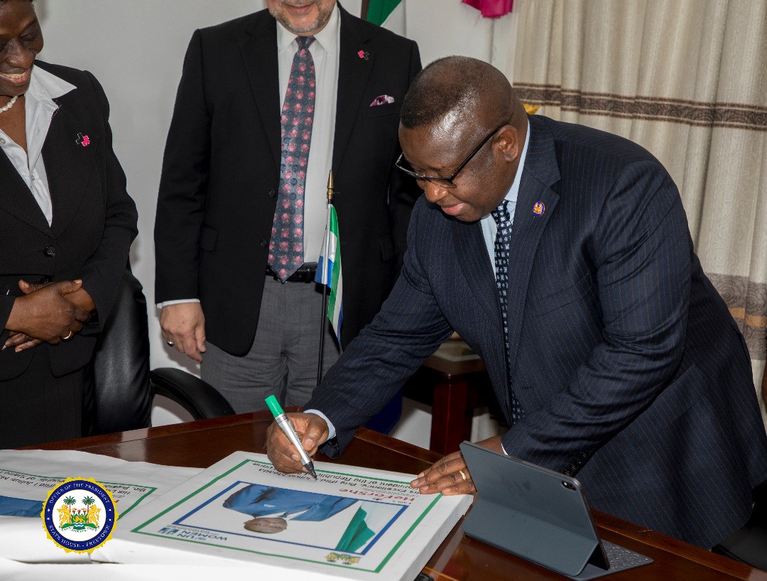 His Excellency Julisus Maada Bio- President of the Republic of Sierra Leone Signing up as HeForShe Champion  flanked by RC-Sierra Leone and UN Women Rep. - State House Sierra Leone 2