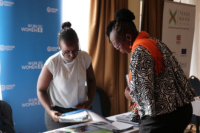 UN Women’s Valentine Waroga attends to visitors at the UN Women stand during the event. Photo: UN Women/ Faith Bwibo