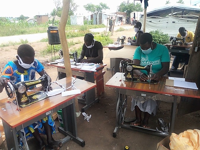 Members of Golden Start Tailoring Group making face masks using the material and machines they received from UN Women in May 2020. The masks are to be sold to members of their community as preventive measure against COVID-19.  Photo: CARE International / Betty Auma