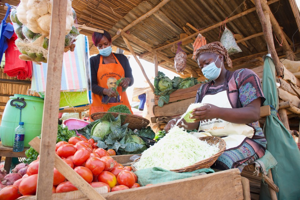 Irene chopping cabbage for customers in her stall in Ugunja. Photo: UN Women/Ben Brewster