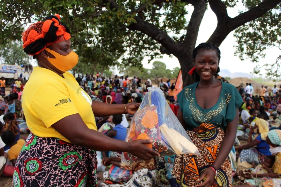 A volunteer from the Association for the Protection of Women and Girls (PROMURA) hands over a dignity kit to an adolescent as part of the support from Direct Relief. Photo_ Boaventura Veja, UN Women Program Officer 
