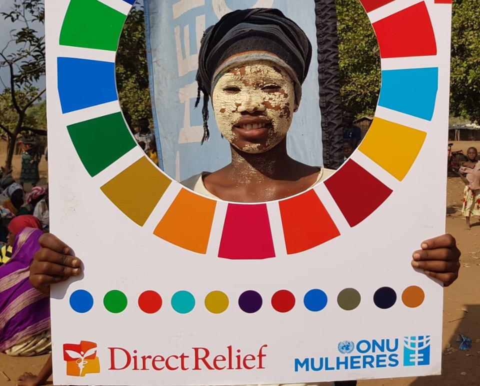 Beneficiary of the dignity kits in the resettlement center use the SDG cardboard for a photo following the allocation of kits supported by Direct Relief in cabo Delgado province to call attention for the need of a humanitarian response focused on women and girls