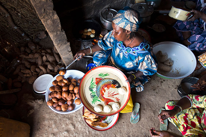 Hadijatou Oumarou helps to make beignets in her friend Nene's restaurant.  The beignets (doughnuts, pictured above being lifted hot out of the frying pan) are a treat for customers and a key source of income at this woman-owned restaurant in the Ngam refu