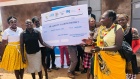 Representatives of savings groups in Kabong established under the LEAP project displaying a dummy check of funds received to boost the groups saving and lending portfolio